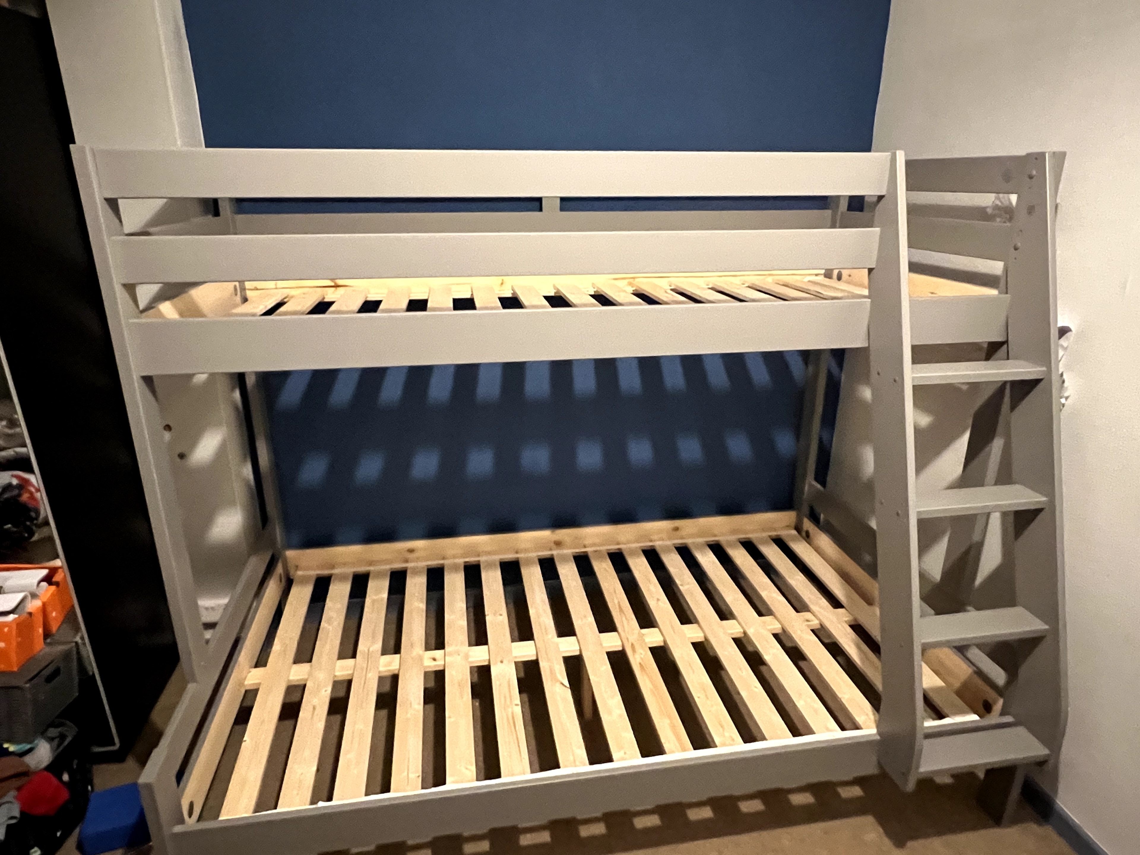 Grey wooden bunk bed with safety rail and ladder assembled