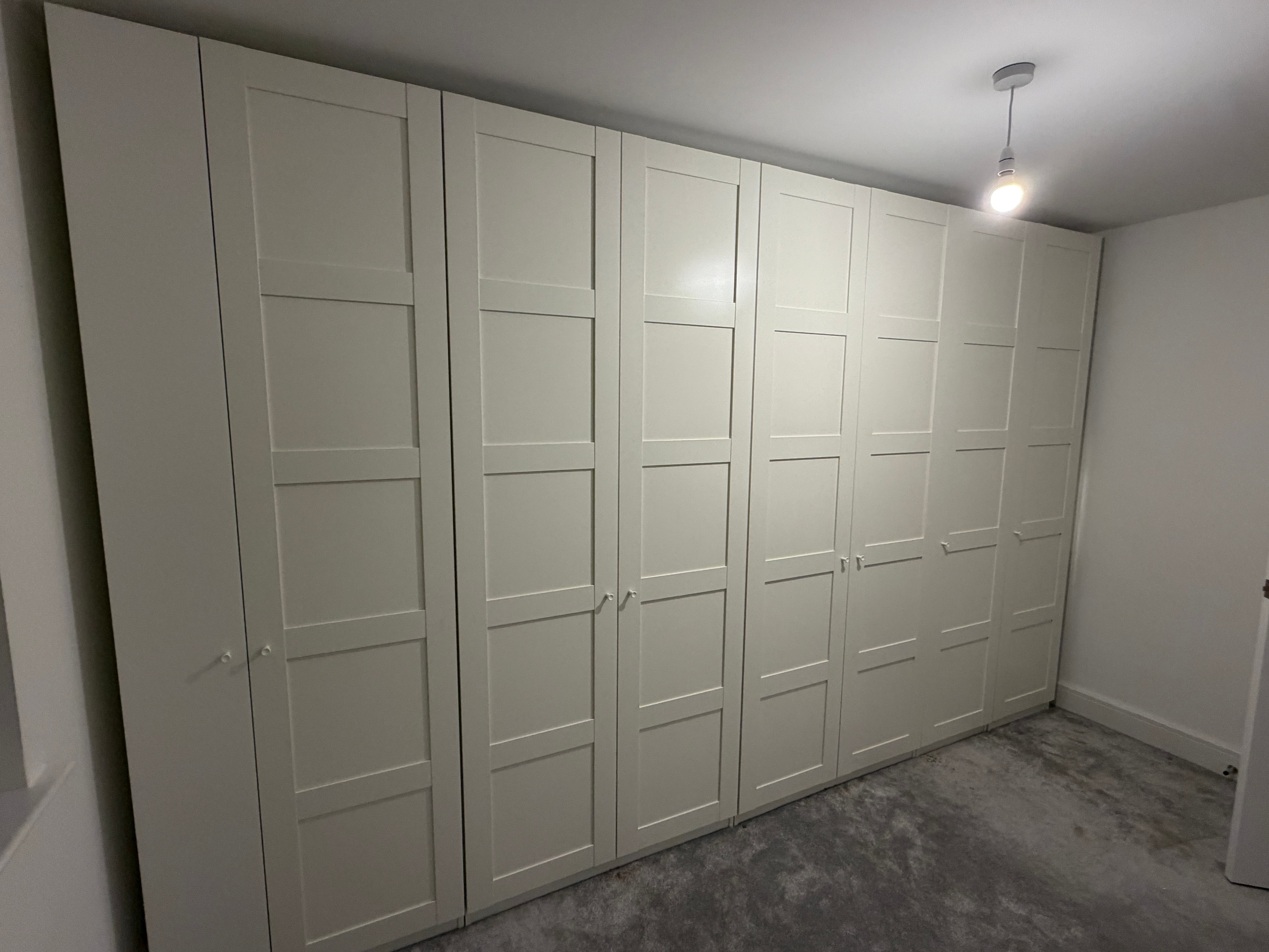 Large multi-door wardrobe fully assembled in bedroom