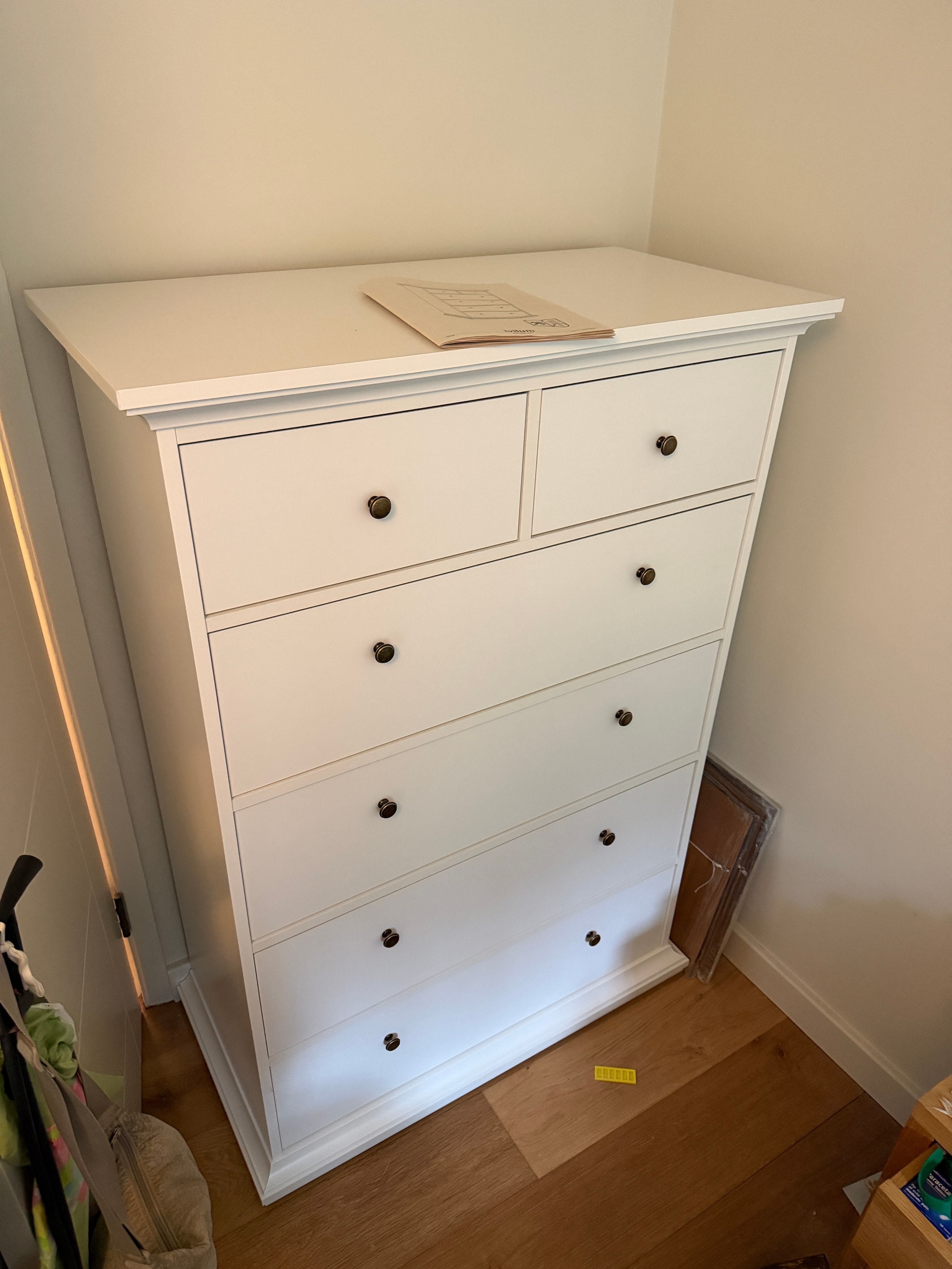 Wide white chest of drawers with round knobs assembled